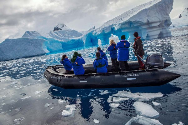 Zodiac cruise Group of people in a zodiac boat with large iceberg in background