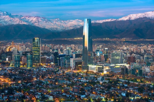 NZ to South America Santiagos modern skyline accentuated by the Andes