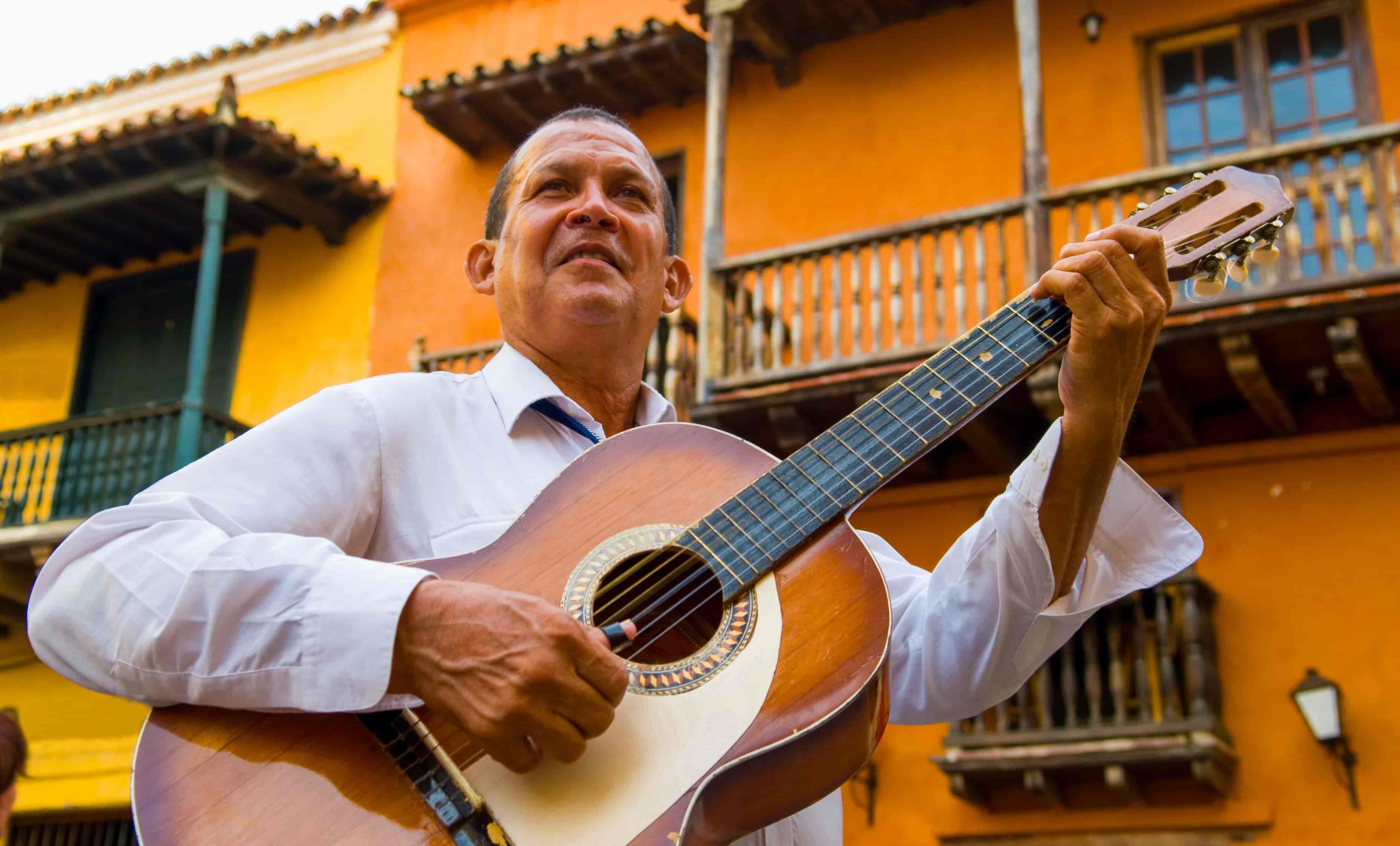Man playing guitar in El Banco, Colombia, birthplace of cumbia music, during a Magdalena River cruise excursion.